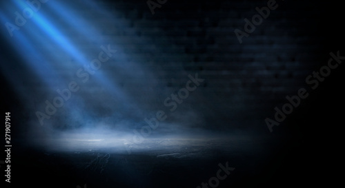 Dark empty scene, blue neon searchlight light, wet asphalt, smoke, night view, rays. Empty black studio room. Dark background. Abstract dark empty studio room texture. Product showcase spotlight back