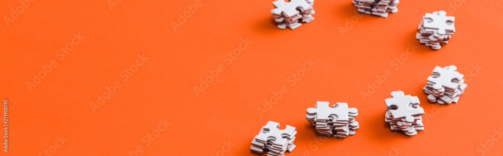 panoramic shot of stacks with white puzzle pieces on orange - obrazy, fototapety, plakaty 