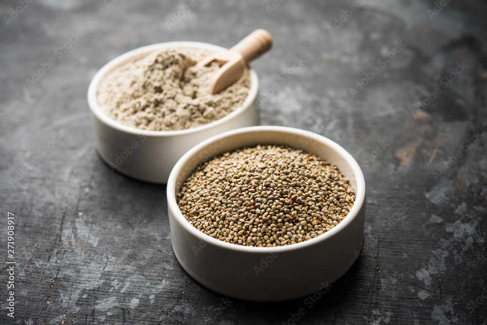 Bajra (pearl millet) / sorghum grains with it's flour or powder in a bowl, selective focus Bajra (pearl millet) / sorghum grains with it's flour or powder in a bowl, selective focus