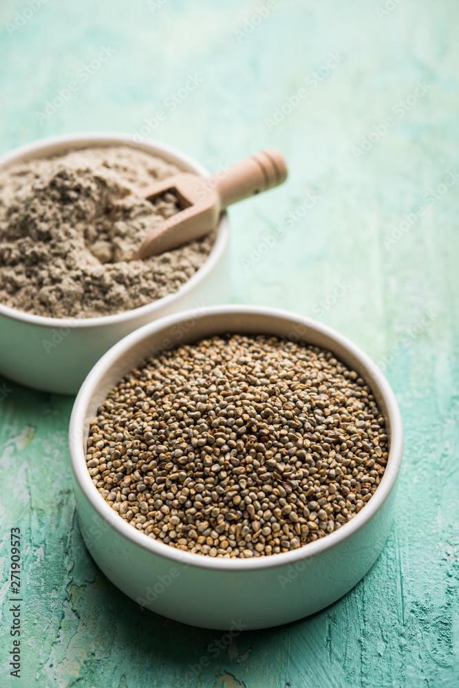 Bajra (pearl millet) / sorghum grains with it's flour or powder in a bowl, selective focus Bajra (pearl millet) / sorghum grains with it's flour or powder in a bowl, selective focus