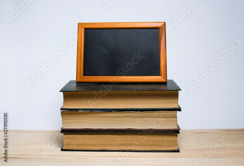 Stack of books and frame with empty place for text on yellow background. Reading books, school, library