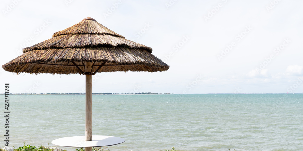 ocean view with straw umbrella beach in web template banner