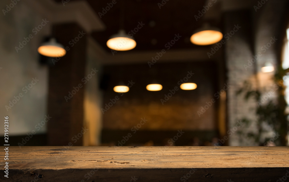 Wood table top with reflect on blur of lighting in night cafe