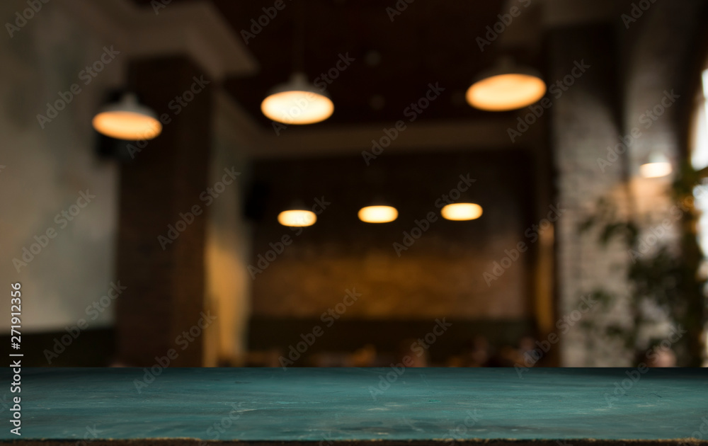 Wood table top with reflect on blur of lighting in night cafe