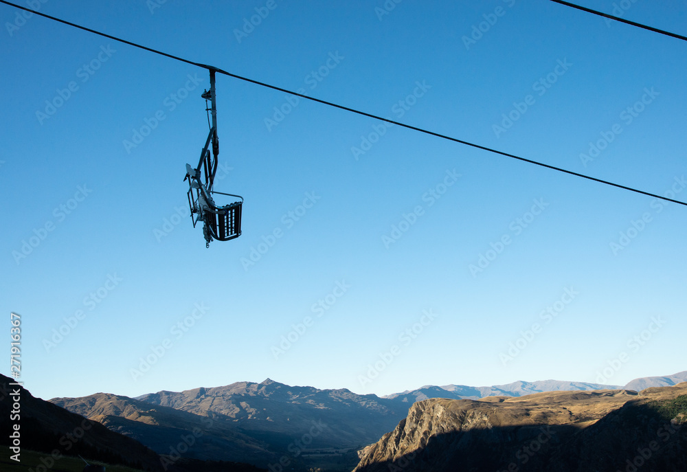 Cableway ski lift over mountain with clear blue sky background in Queentown city, New Zealand.