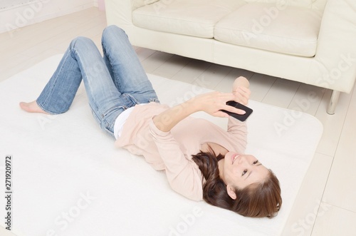 寝転んでスマホを見る女性 Stock 写真 Adobe Stock