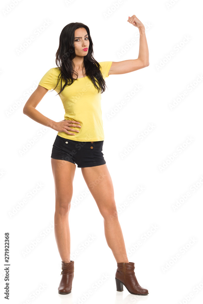 Confident Young Woman Is Standing And Flexing Muscles Confident Young Woman Is Standing And Flexing Muscles