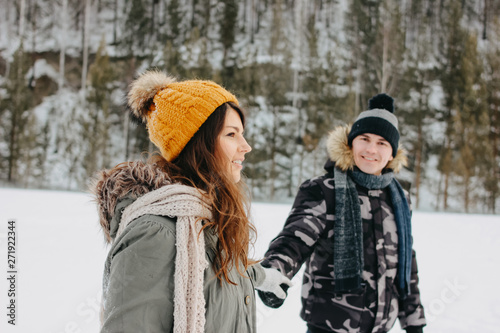 The happy couple in love at the forest nature park in cold season. Travel adventure love story