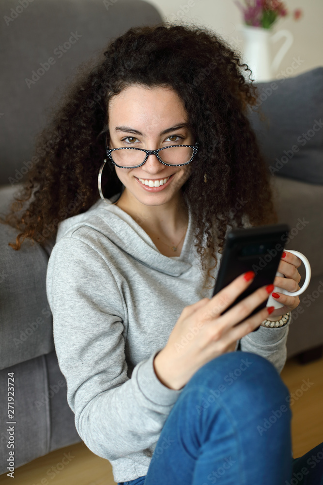 Relaxed casual girl texting on smartphone at home Relaxed casual girl texting on smartphone at home