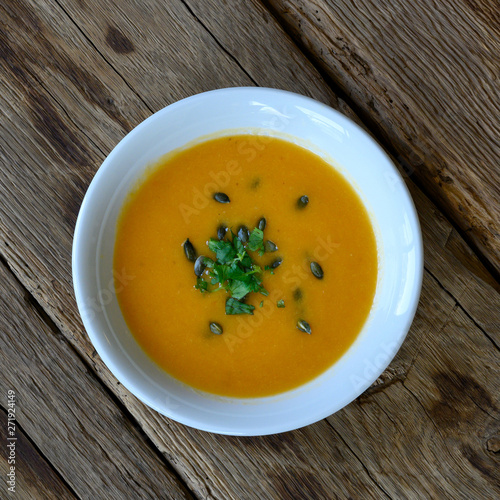 Pumpkin soup puree on wood deck.