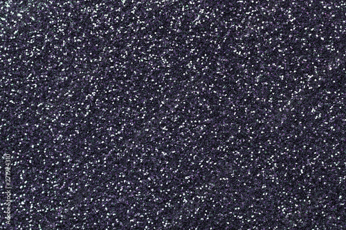 Dark gray sparkling background from small sequins, closeup. Brilliant blue backdrop.