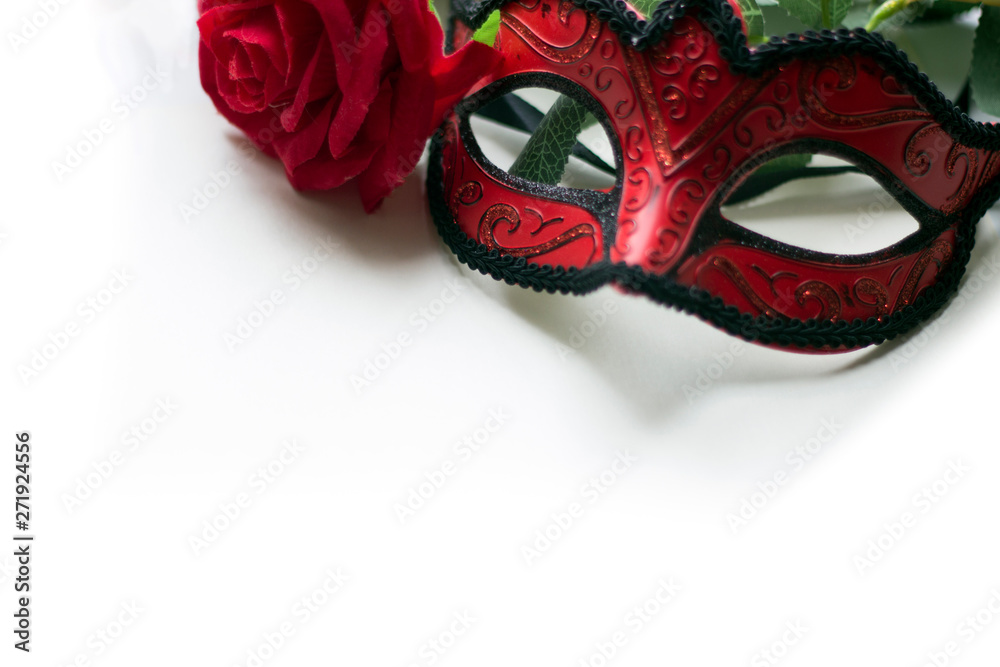 Venice carnival mask and red rose on a white background top view. Romantic concept, copy space