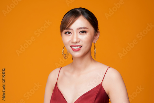 Beautiful woman face close up portrait young studio on yellow