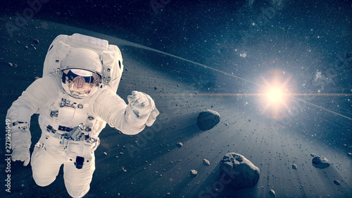 Astronaut flying in a deep space. Space scene. Meteor belt on the background. Elements of this image furnished by NASA.
