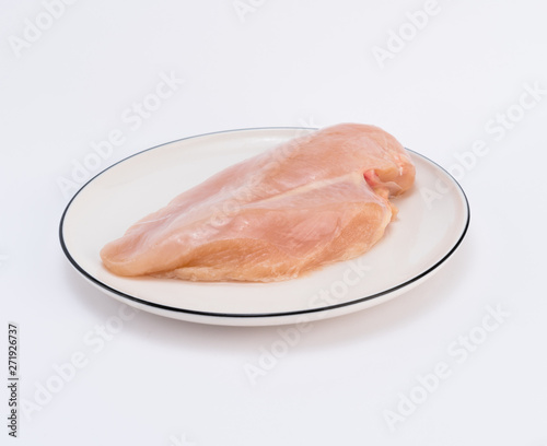 Raw chicken breast fillets on white dish