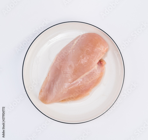 Raw chicken breast fillets on white dish