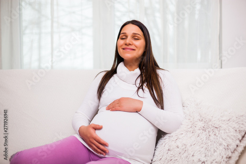 Happy pregnant woman relaxing at home. 