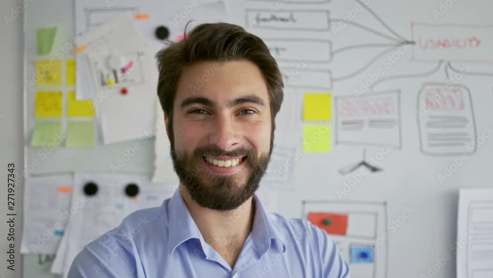 Young startup entrepreneur smiling at camera in front of office whiteboard Young startup entrepreneur smiling at camera in front of office whiteboard