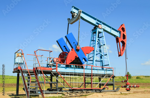 Oil pump are working in the blue sky background © Aleksandr Kurganov