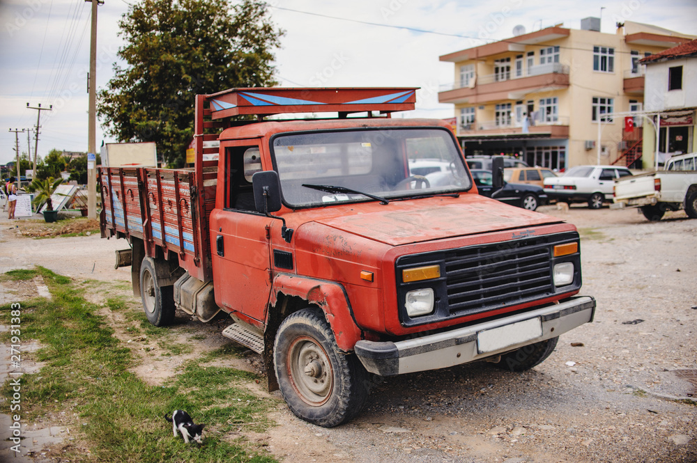 The old freight car on the street near the house. Road. Turkey. Close up. Truck.