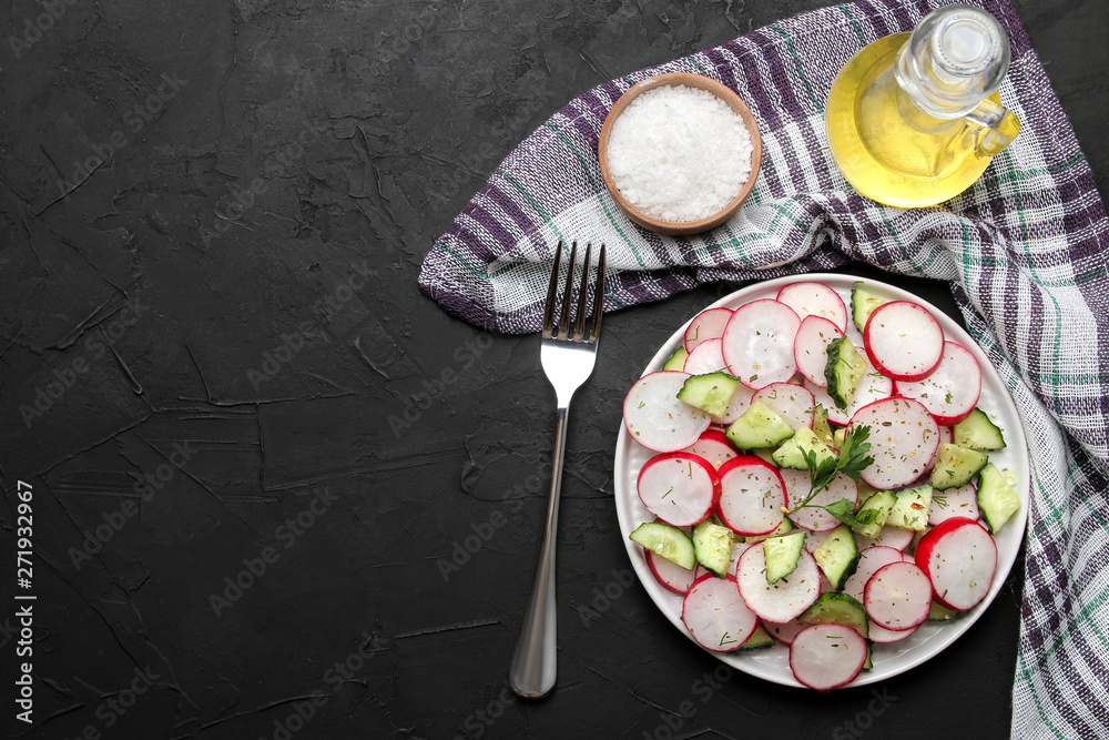 Fresh radish and cucumber salad and greens on a black concrete table. Salad of spring vegetables. ingredients for making salad. top view Fresh radish and cucumber salad and greens on a black concrete table. Salad of spring vegetables. ingredients for making salad. top view