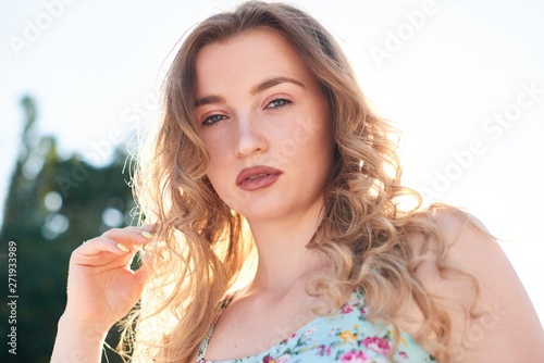 open space portrait of blond curve hair woman, summer fashion