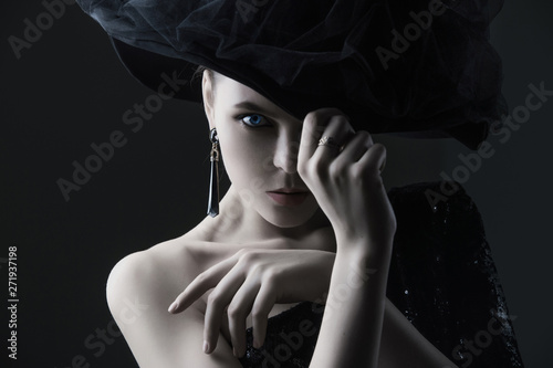high fashion portrait of elegant woman in black and white hat and dress.