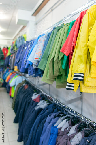 Children winter clothing on hangers in clothing shop interior