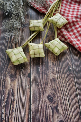 Ketupat (Rice Dumpling) On Wooden Background. Ketupat is a natural rice casing made from young coconut leaves for cooking rice during eid Mubarak, Fitri 