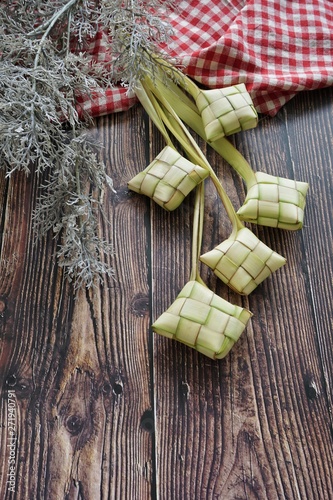 Ketupat (Rice Dumpling) On Wooden Background. Ketupat is a natural rice casing made from young coconut leaves for cooking rice during eid Mubarak, Fitri 