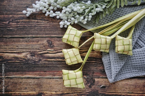 Ketupat (Rice Dumpling) On Wooden Background. Ketupat is a natural rice casing made from young coconut leaves for cooking rice during eid Mubarak, Fitri 