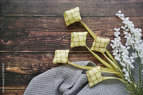 Ketupat (Rice Dumpling) On Wooden Background. Ketupat is a natural rice casing made from young coconut leaves for cooking rice during eid Mubarak, Fitri 