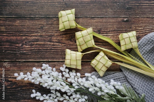 Ketupat (Rice Dumpling) On Wooden Background. Ketupat is a natural rice casing made from young coconut leaves for cooking rice during eid Mubarak, Fitri 