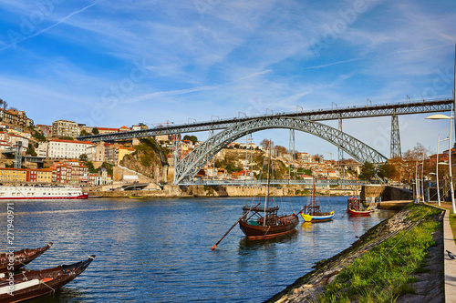 Typical portuguese wooden boats  called  barcos rabelos  transporting wine barrels on the river Douro with view on Villa Nova de Gaia  in Porto  Portugal