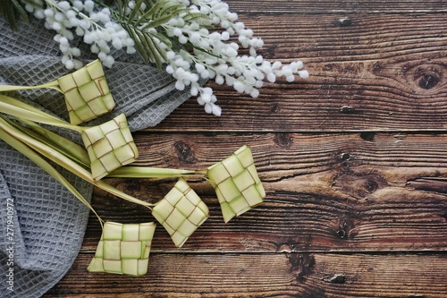 Ketupat (Rice Dumpling) On Wooden Background. Ketupat is a natural rice casing made from young coconut leaves for cooking rice during eid Mubarak, Fitri 