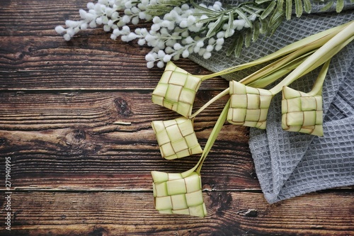 Ketupat (Rice Dumpling) On Wooden Background. Ketupat is a natural rice casing made from young coconut leaves for cooking rice during eid Mubarak, Fitri 