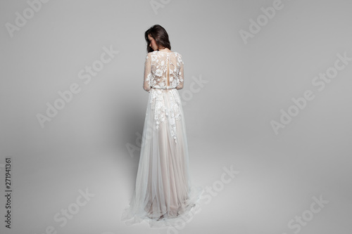 Image of bride from the back, graceful young woman in long wendding dress, isolated on a white background. photo