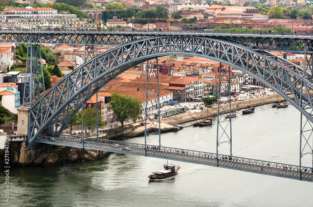Fototapeta premium Riverboat sailing on the river Douro, with double-deck metal arch bridge. Porto.