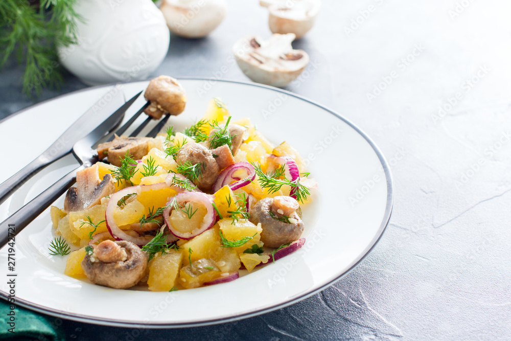 Potato salad with pickled champignons and cucumbers on a white plate, horizontal, copy space Potato salad with pickled champignons and cucumbers on a white plate, horizontal, copy space