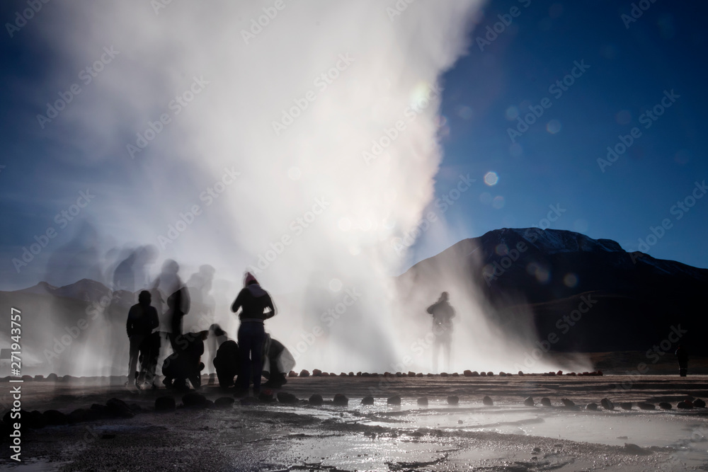 Atacama desert, Chile: Bright rising sun behind erupting Hot Geyser Of Steam in El Tatio Geysers field at early morning sunrise