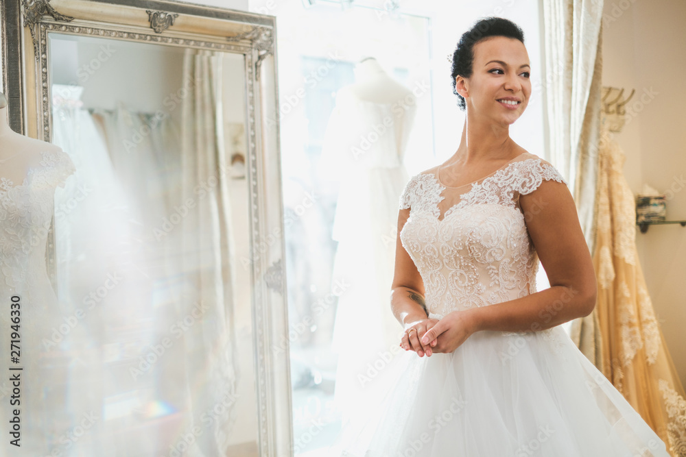 Beautifu bride choosing wedding dress in a wedding salon Beautifu bride choosing wedding dress in a wedding salon
