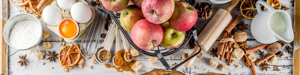 Autumn baking sale concept. Cooking seasonal fall baking background with ingredients, spices, apples, supplies, white wooden table top view copy space