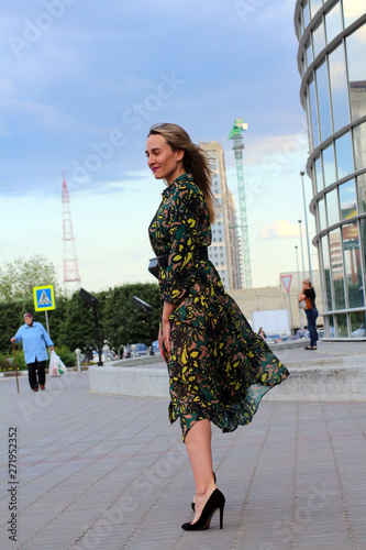girl in green dress with long legs on city street