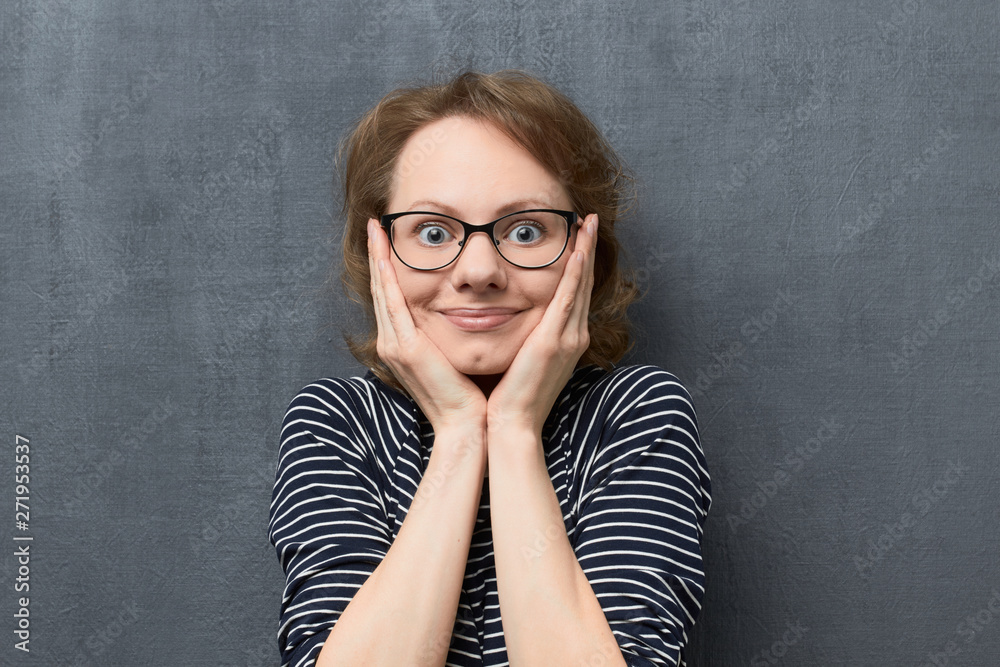 Portrait of surprised girl holding hands on cheeks Portrait of surprised girl holding hands on cheeks