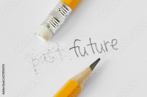 The word past erased with a rubber and the word future written with a pencil on white paper - Concept of time, clearing the past and building a future photo