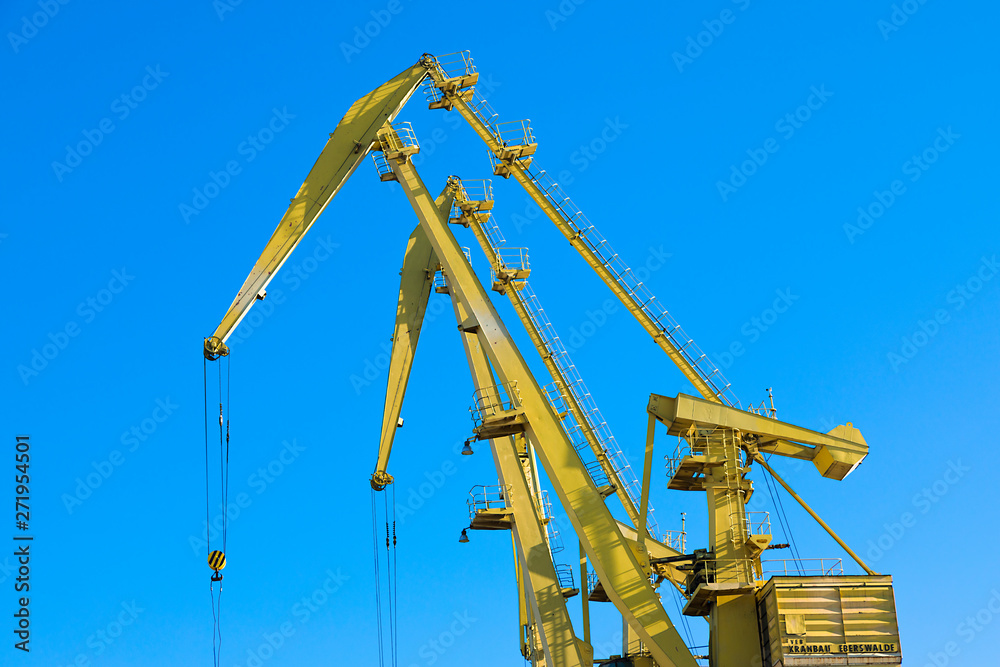Mobile harbor cranes over blue sky. Transport and technology concept Mobile harbor cranes over blue sky. Transport and technology concept