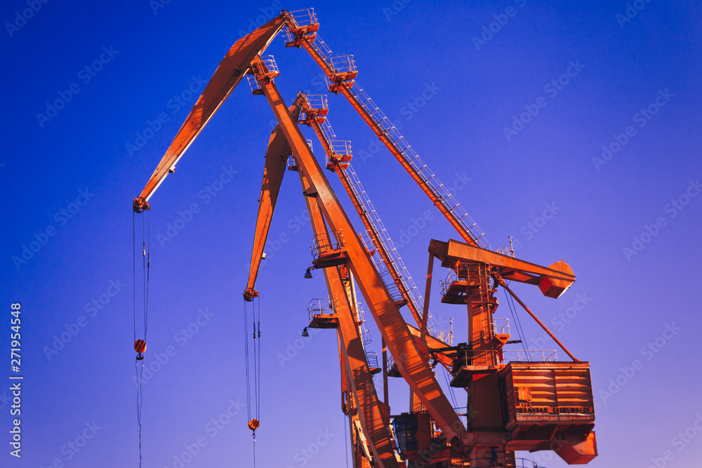 Mobile harbor cranes over blue sky. Transport and technology concept Mobile harbor cranes over blue sky. Transport and technology concept