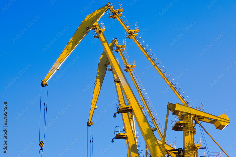 Mobile harbor cranes over blue sky. Transport and technology concept Mobile harbor cranes over blue sky. Transport and technology concept