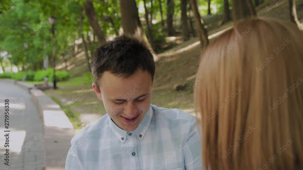 Beautiful happy couple in love sitting on a bench in the park and talking. Beautiful happy couple in love sitting on a bench in the park and talking.