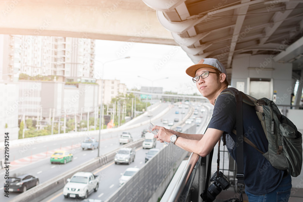 Asian man traveler backpacker looking the city in the skytrain station. Asian man traveler backpacker looking the city in the skytrain station.